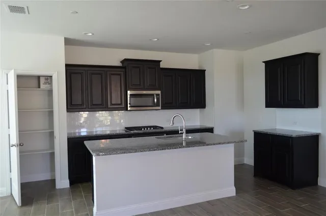 a kitchen with stainless steel appliances granite countertop a sink stove and microwave