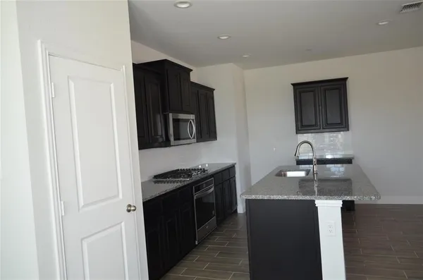 a kitchen with stainless steel appliances granite countertop a stove and a refrigerator