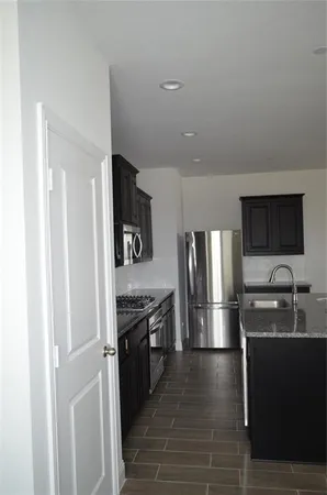 a kitchen with stainless steel appliances granite countertop a refrigerator and a sink