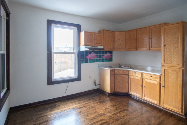 2519 North Pulaski Road Chicago, IL 60639 - Photo 15 of 36 a kitchen with granite countertop white cabinets and white appliances