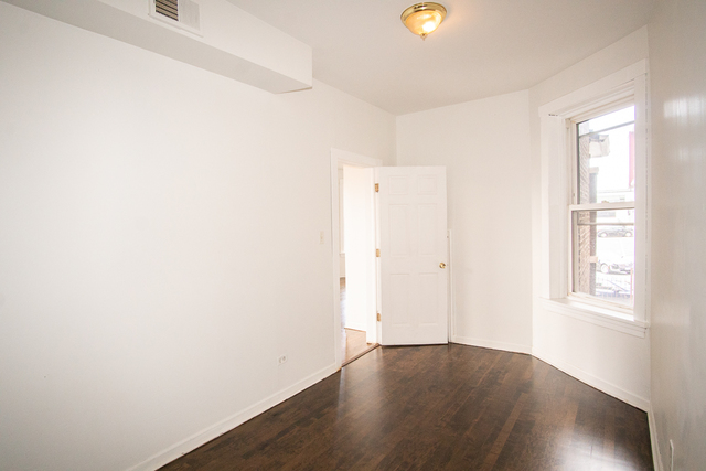 2519 North Pulaski Road Chicago, IL 60639 - Photo 17 of 36 an empty room with wooden floor and windows