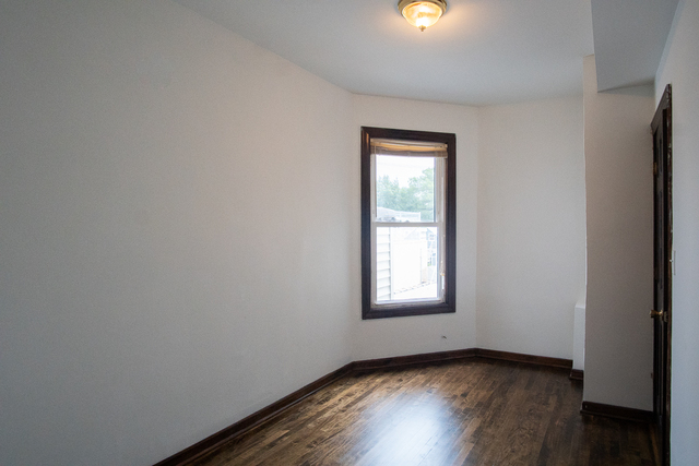 2519 North Pulaski Road Chicago, IL 60639 - Photo 3 of 36 an empty room with wooden floor and windows