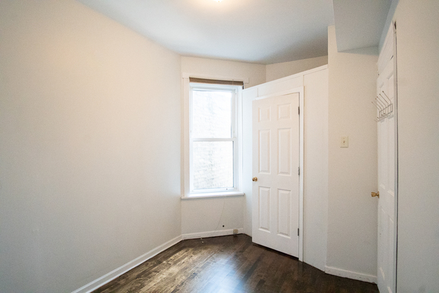 2519 North Pulaski Road Chicago, IL 60639 - Photo 21 of 36 an empty room with wooden floor and window