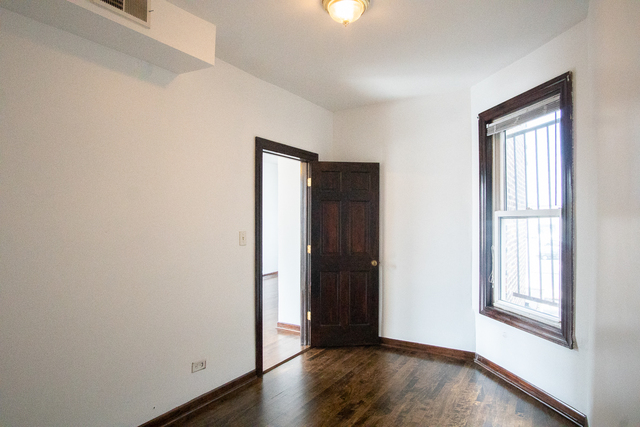 2519 North Pulaski Road Chicago, IL 60639 - Photo 4 of 36 an empty room with wooden floor and windows