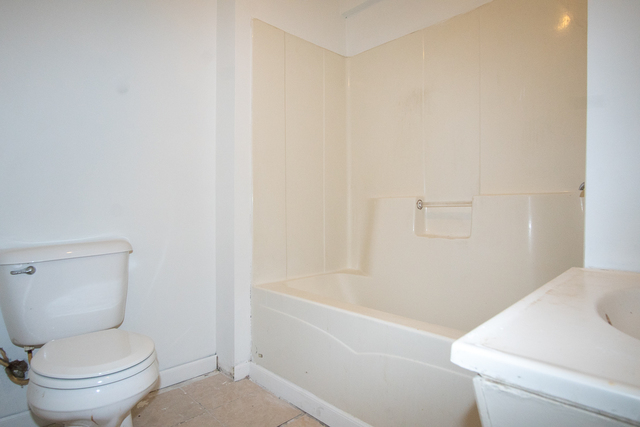 2519 North Pulaski Road Chicago, IL 60639 - Photo 33 of 36 a white toilet sitting next to a bath tub