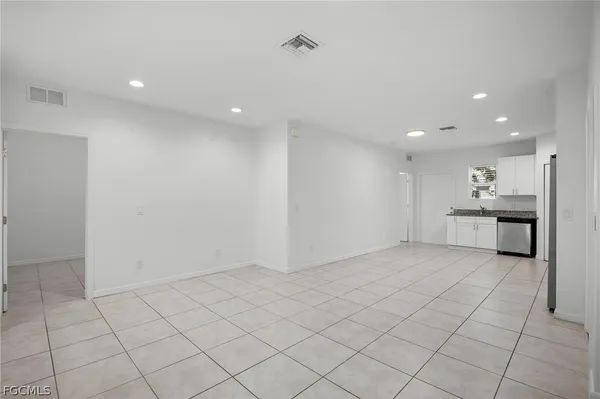an empty room with kitchen view