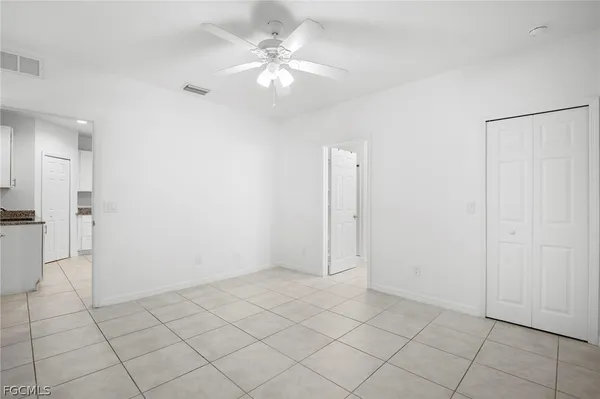 an empty room with a window and a fan