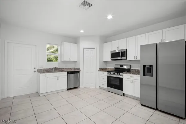 a kitchen with granite countertop appliances cabinets and a sink