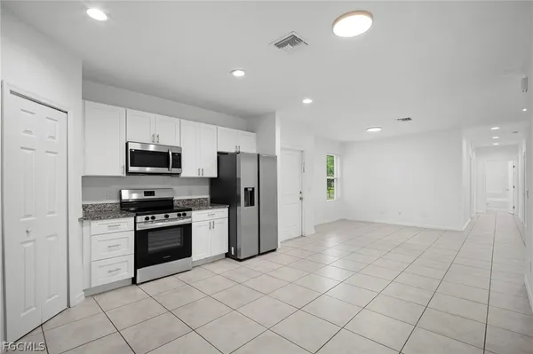 a kitchen with stainless steel appliances granite countertop a refrigerator and a stove top oven