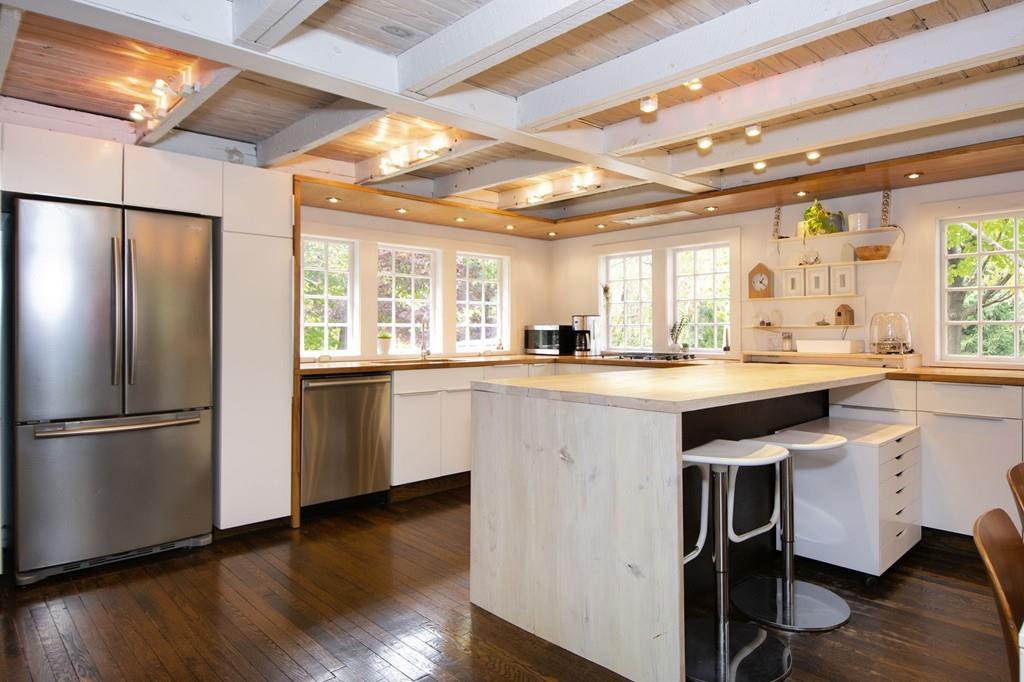 6 Turner Road Scituate, MA 02066 - Photo 7 of 28 a kitchen with kitchen island granite countertop a refrigerator a sink dishwasher and white cabinets with wooden floor