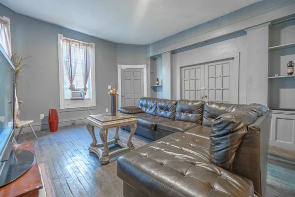 a living room with furniture a wooden floor and a window