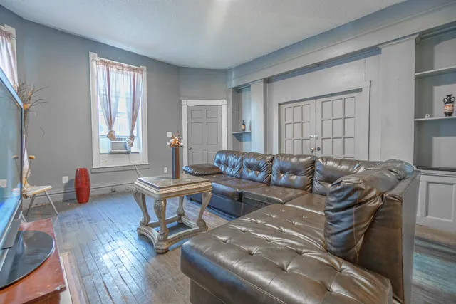 a living room with furniture a wooden floor and a window