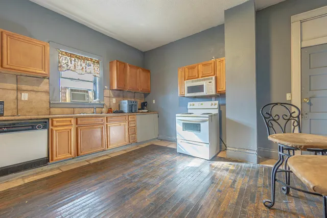 a kitchen with a sink cabinets wooden floor and stainless steel appliances