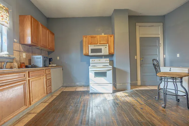 a kitchen with a wooden floor and a refrigerator