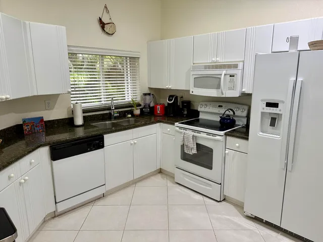 a kitchen with white cabinets and white appliances