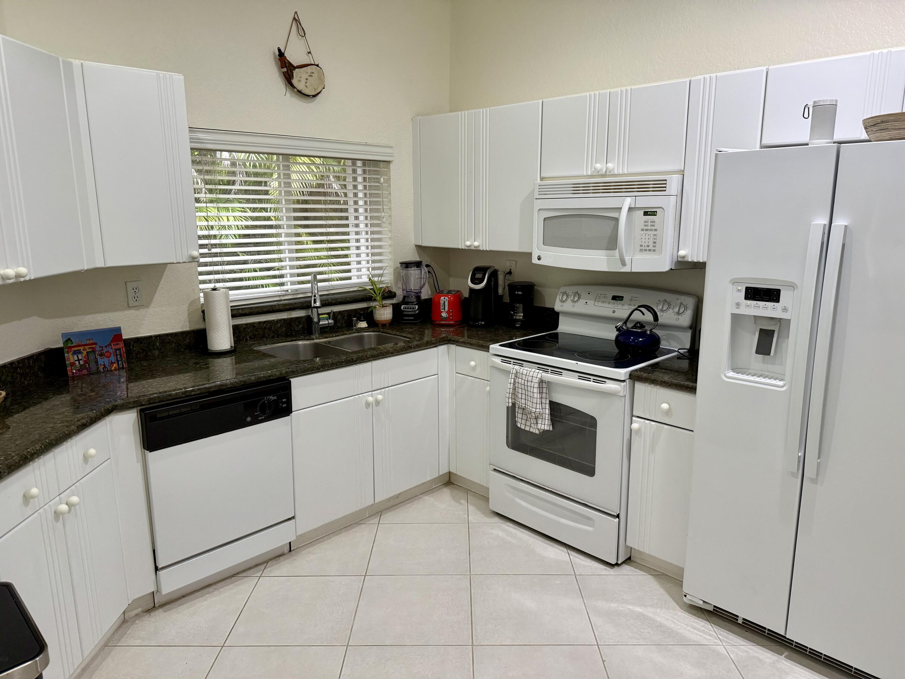 15864 Southwest 10th Street Pembroke Pines, FL 33027 - Photo 3 of 11 a kitchen with white cabinets and white appliances