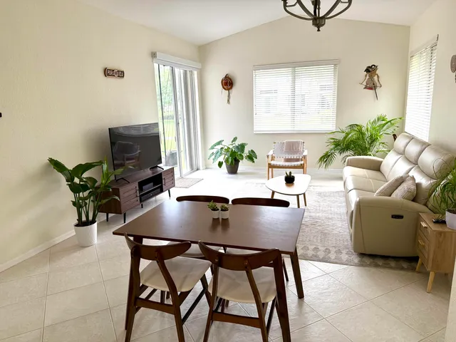 a living room with fireplace furniture and a potted plant