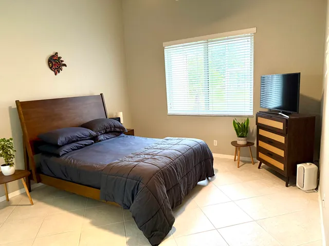 a bedroom with a bed and flat screen tv
