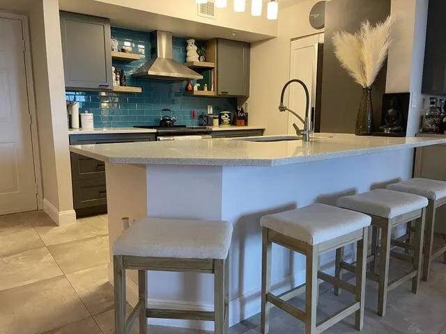 a kitchen with stainless steel appliances kitchen island granite countertop a sink a stove and cabinets