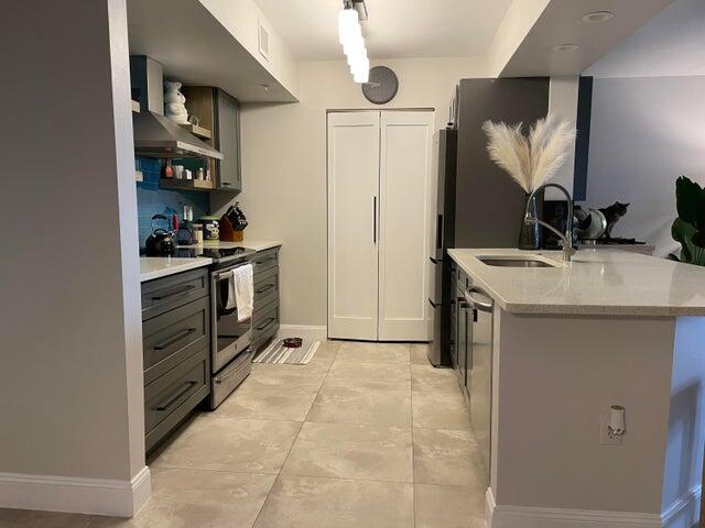 1200 Scotia Drive, Unit 305 Hypoluxo, FL 33462 - Photo 5 of 28 a kitchen with stainless steel appliances granite countertop a sink stove and refrigerator
