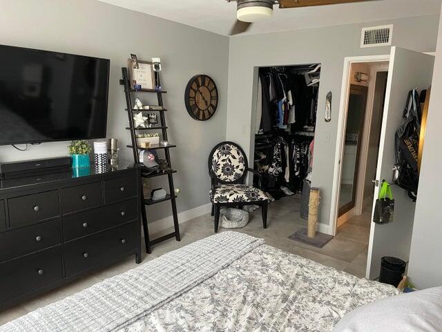 1200 Scotia Drive, Unit 305 Hypoluxo, FL 33462 - Photo 9 of 28 a bedroom with a bed a mirror on dresser and a flat tv screen on the dresser