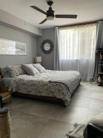1200 Scotia Drive, Unit 305 Hypoluxo, FL 33462 - Photo 10 of 28 a bedroom with a bed and a dresser next to a window