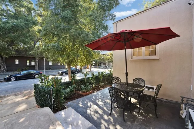 a view of a table and chairs under an umbrella in backyard