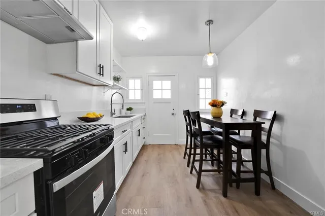 a kitchen with a table chairs stove and cabinets