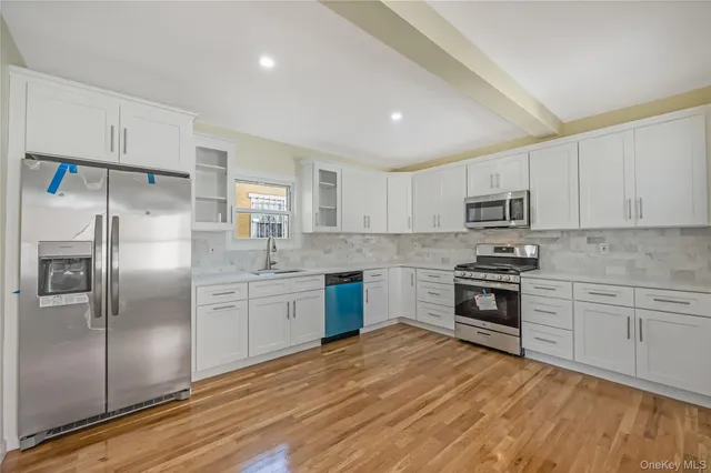 a kitchen with granite countertop a refrigerator stove and sink