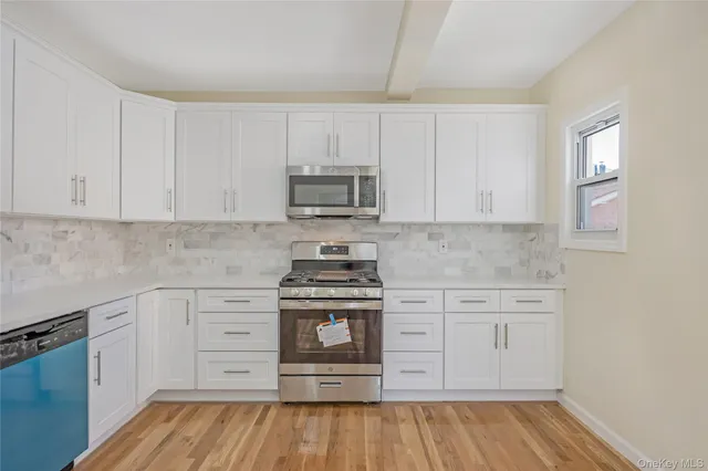 a kitchen with cabinets appliances and a wooden floor