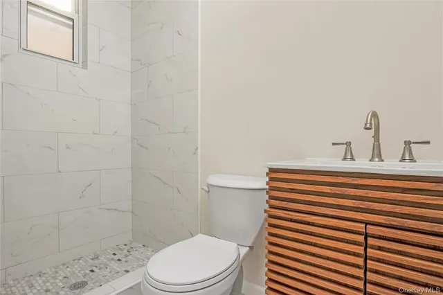 a bathroom with a sink a toilet and shower