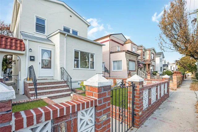 a view of a brick house with large windows and a small yard