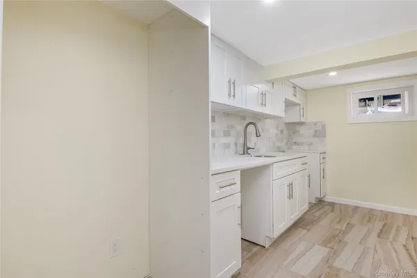 a kitchen with granite countertop white cabinets and sink