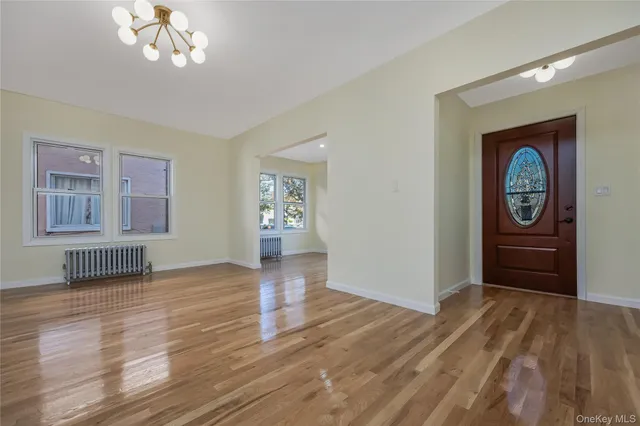 a view of empty room with window and wooden floor