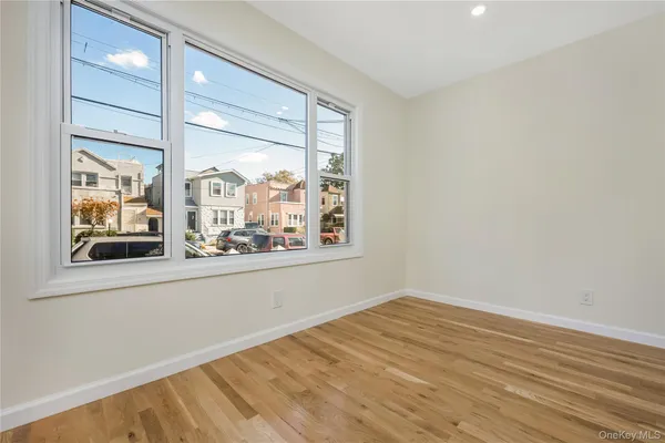 an empty room with wooden floor and a window