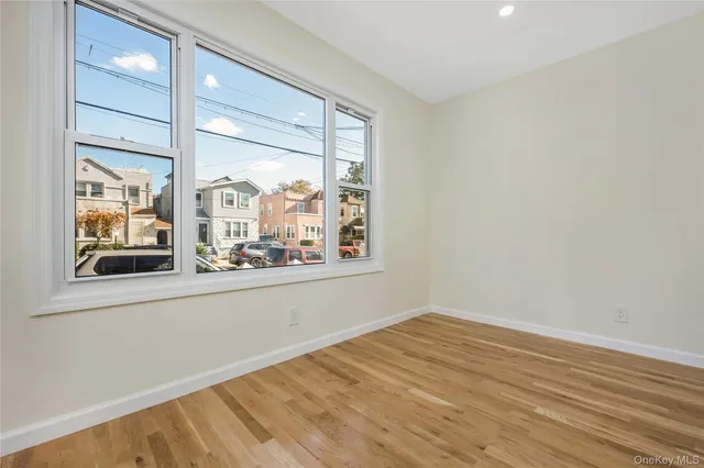 an empty room with wooden floor and a window