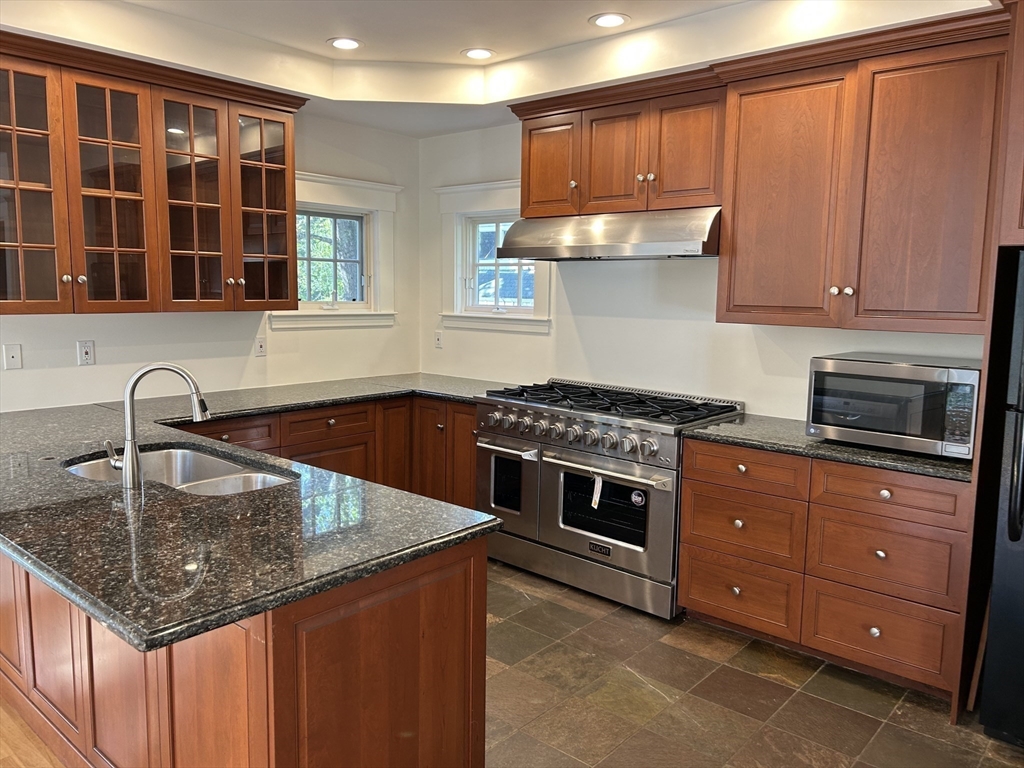 99 Tower Road Lincoln, MA 01773 - Photo 17 of 42 a kitchen with stainless steel appliances granite countertop a sink stove and cabinets
