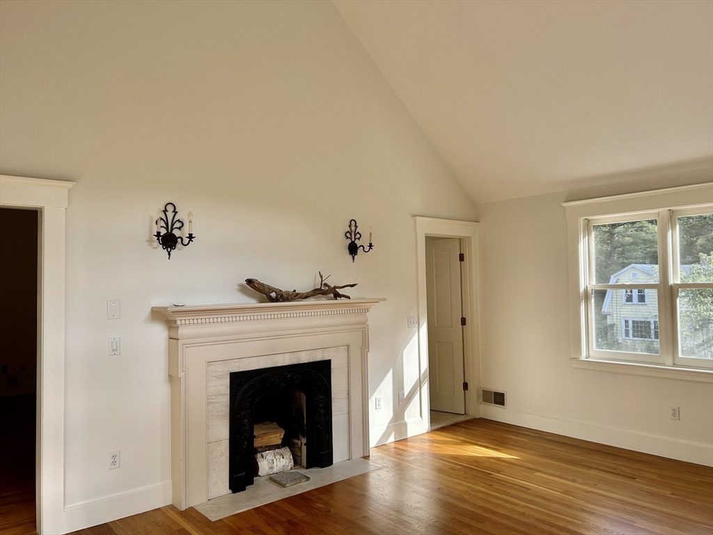 99 Tower Road Lincoln, MA 01773 - Photo 26 of 42 a living room with a fireplace and wooden floor