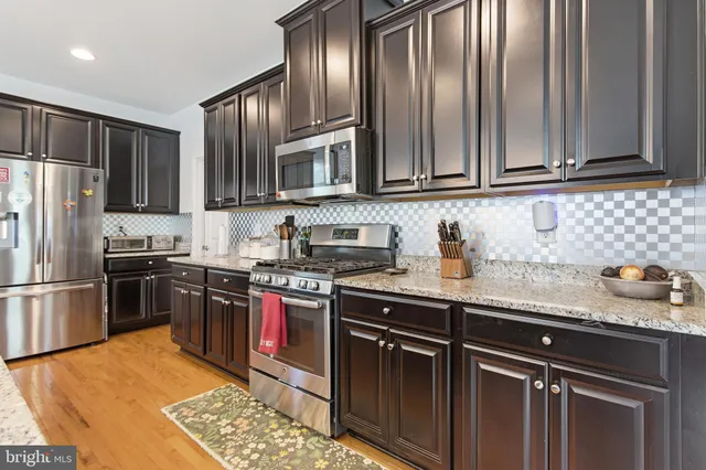 a kitchen with granite countertop stainless steel appliances and wooden cabinets