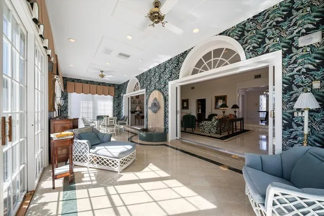 a living room with furniture a fireplace and a chandelier