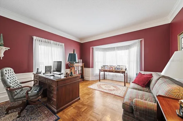 a living room with furniture a large window and gym equipment
