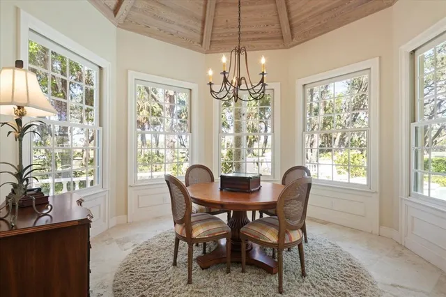 a dining room with furniture a fireplace and large window