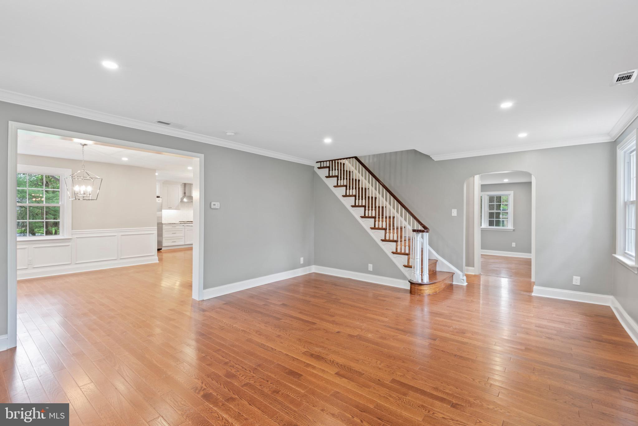 103 East Rose Valley Road Wallingford, PA 19086 - Photo 12 of 75 a view of an empty room with wooden floor staircase and a kitchen