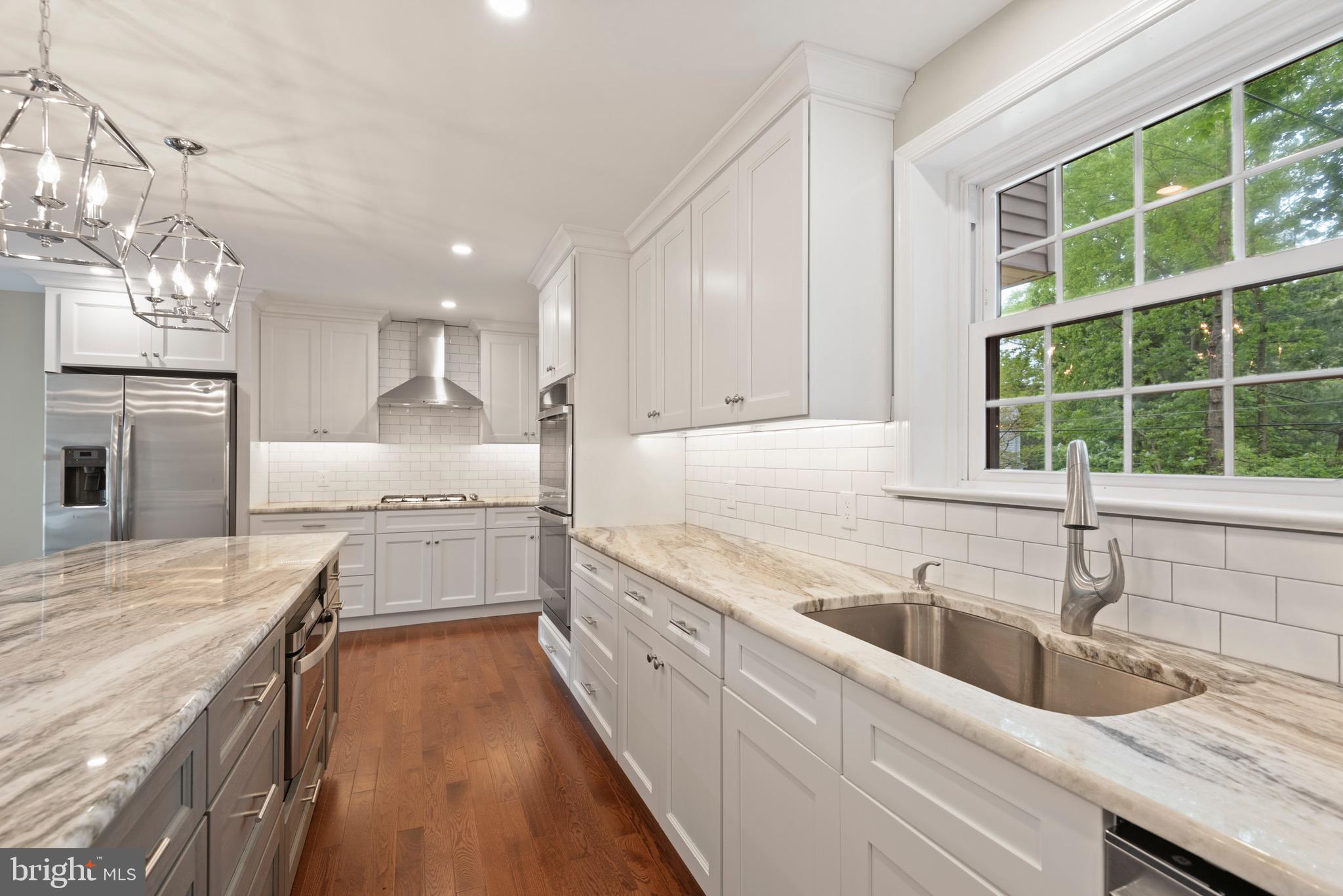 103 East Rose Valley Road Wallingford, PA 19086 - Photo 20 of 75 a kitchen with granite countertop a sink stainless steel appliances cabinets and a large window