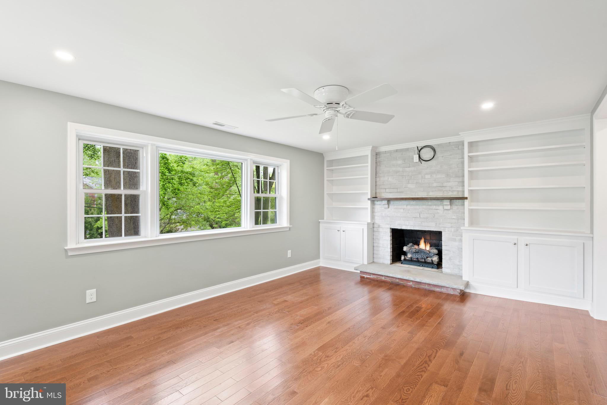 103 East Rose Valley Road Wallingford, PA 19086 - Photo 31 of 75 an empty room with windows fireplace and wooden floor