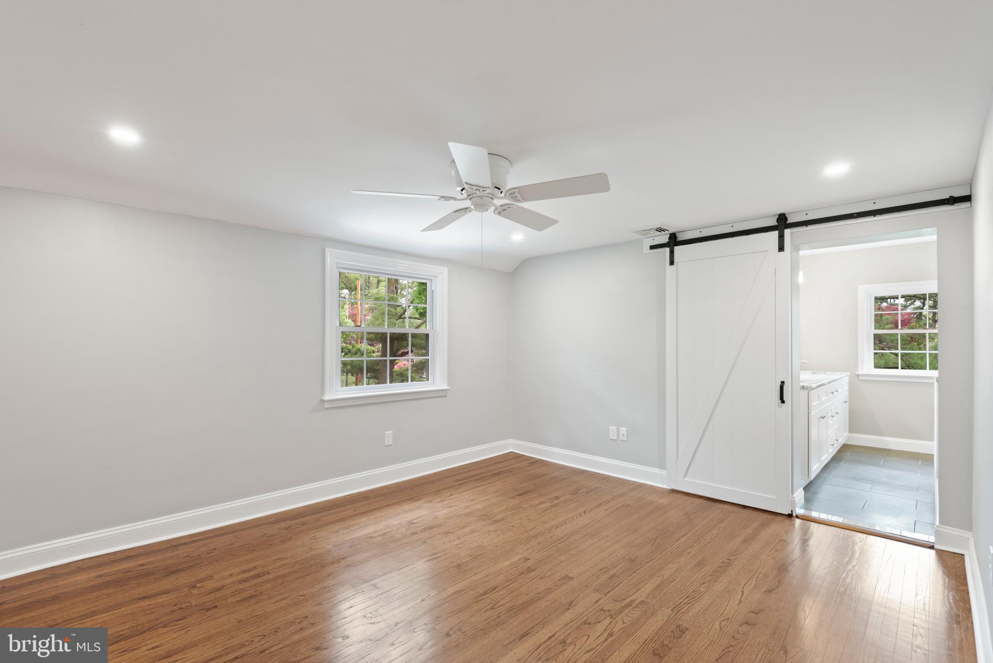 103 East Rose Valley Road Wallingford, PA 19086 - Photo 34 of 75 an empty room with wooden floor fan and windows