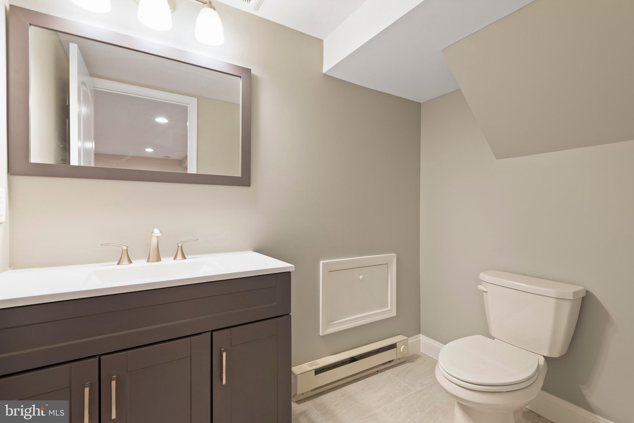 103 East Rose Valley Road Wallingford, PA 19086 - Photo 53 of 75 a bathroom with a toilet a sink a vanity and mirror