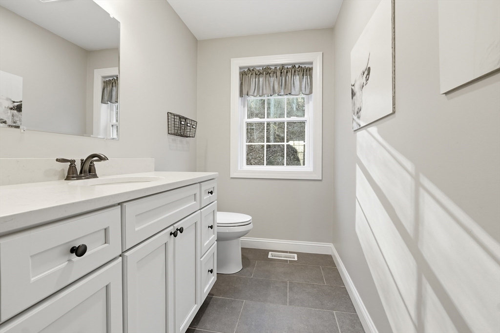 103 Rice Corner Road Brookfield, MA 01506 - Photo 18 of 39 a bathroom with a double vanity sink toilet and a tub