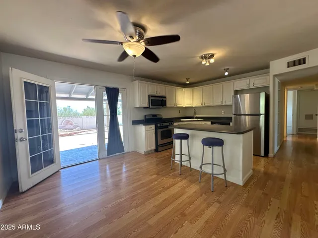 a kitchen with granite countertop a refrigerator and steel appliances