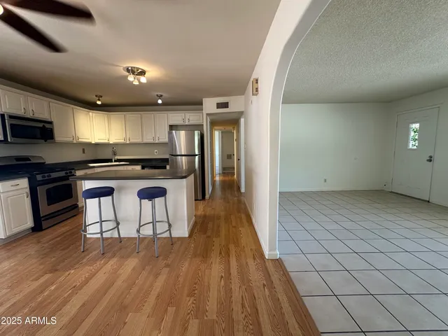 a kitchen with stainless steel appliances granite countertop a stove a sink and a refrigerator